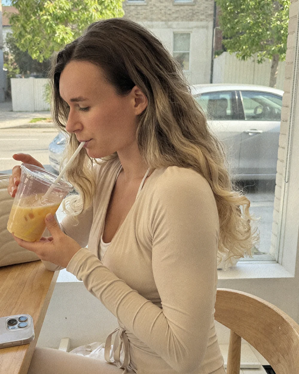 Marion qui savoure une boisson glacée en terrasse